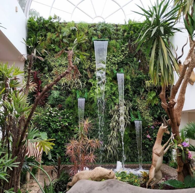 Jardín vertical de gran formato combinado con una cascada de agua en un atrio interior