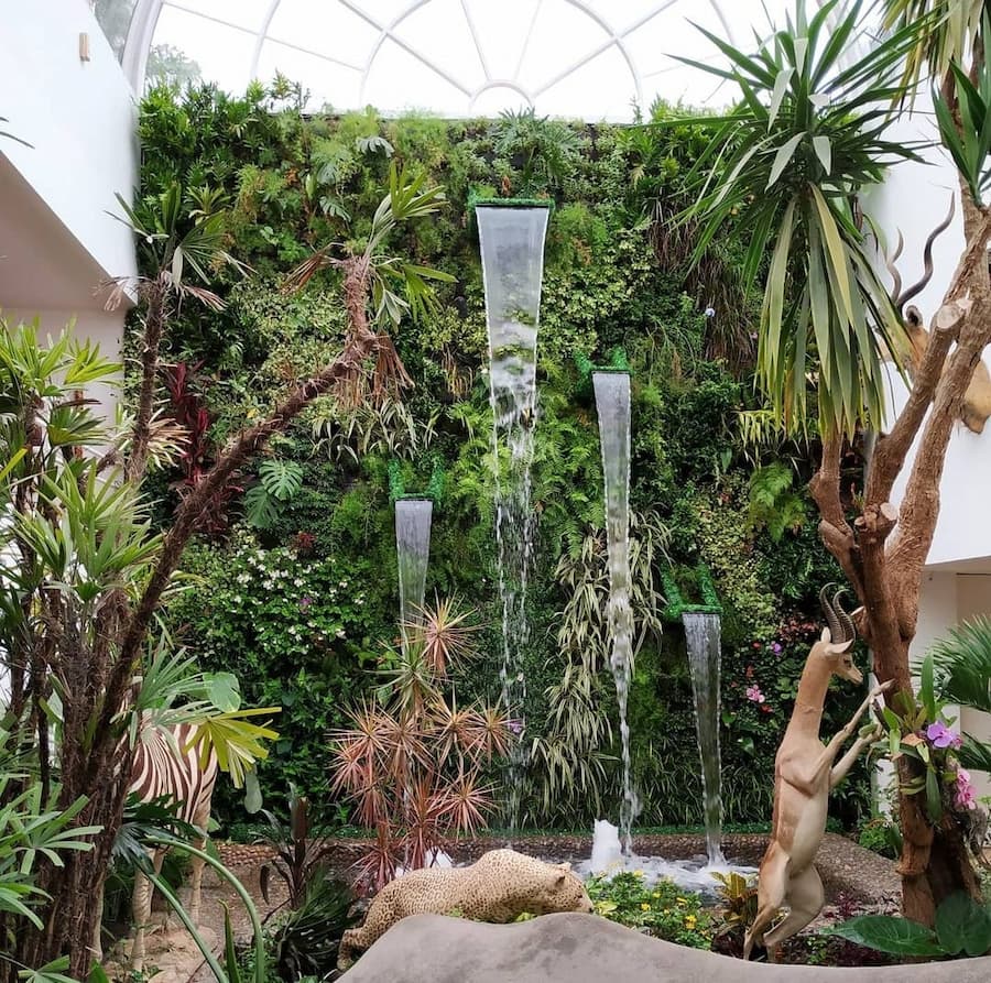 Jardín vertical de gran formato combinado con una cascada de agua en un atrio interior