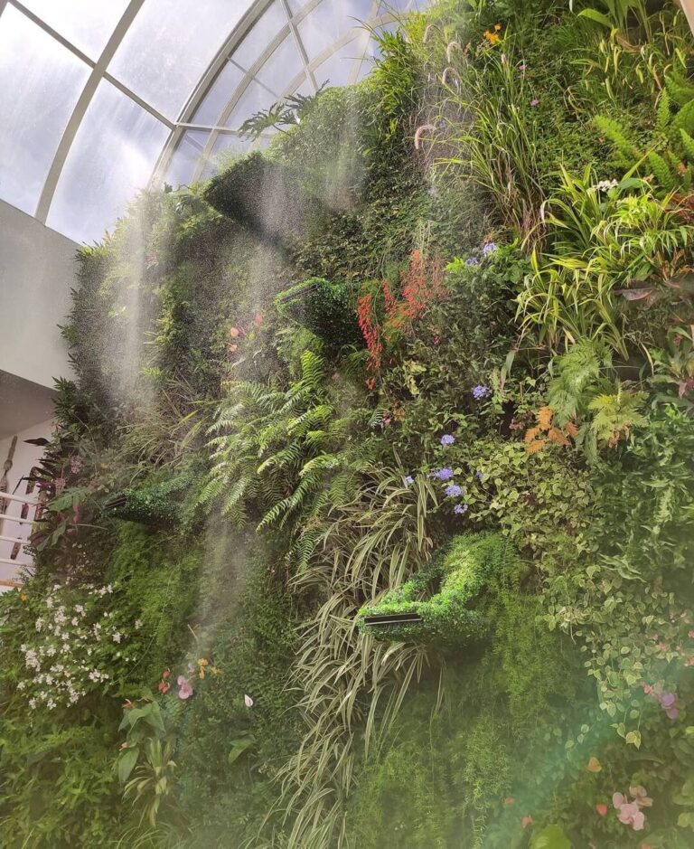 Jardín vertical de gran altura en un espacio interior acristalado, con riego por nebulización