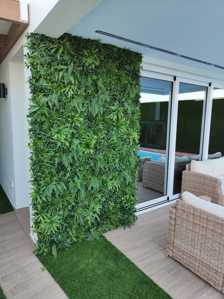 Jardín vertical instalado en una terraza junto a la piscina, con muebles de exterior, en Las Palmas de Gran Canaria